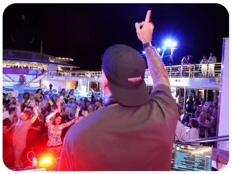 A DJ entertaining a crowd on a cruise ship at night